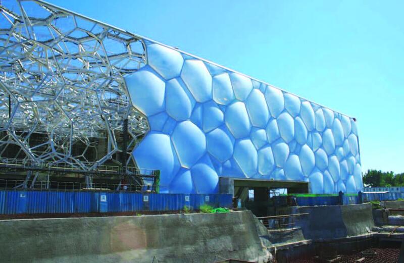 Монтаж стен из пузырьков при строительстве водного стадиона. Слева видны открытые конструкции несущего каркаса
